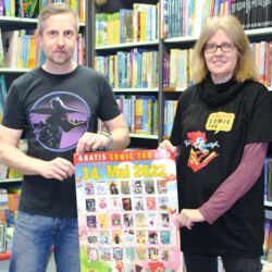 Bibliotheksmitarbeiter Marko Schönwelski und Buchladenbesitzerin Ulrike Wiechert mit Plakat und Shirt zum Gratis-Comic-Tag; (c) Frauke Naumann