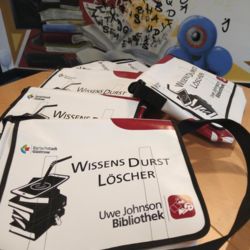 Mehrere Taschen aus LKW-Plane mit dem Aufdruck "WissensDurstLöscher", die nun in der Bibliothek mit ausgeliehen werden können.