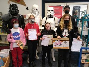 Vier Kostümträger des Fanclubs "German Garrison" posieren mit Teilnehmerinnen des Ferienleseclubs