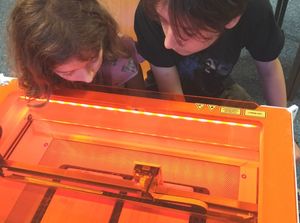 Jetta und Vito Kirchwehm beobachten den Lasercutter beim Holzgravieren ; (c) Barlachstadt Güstrow